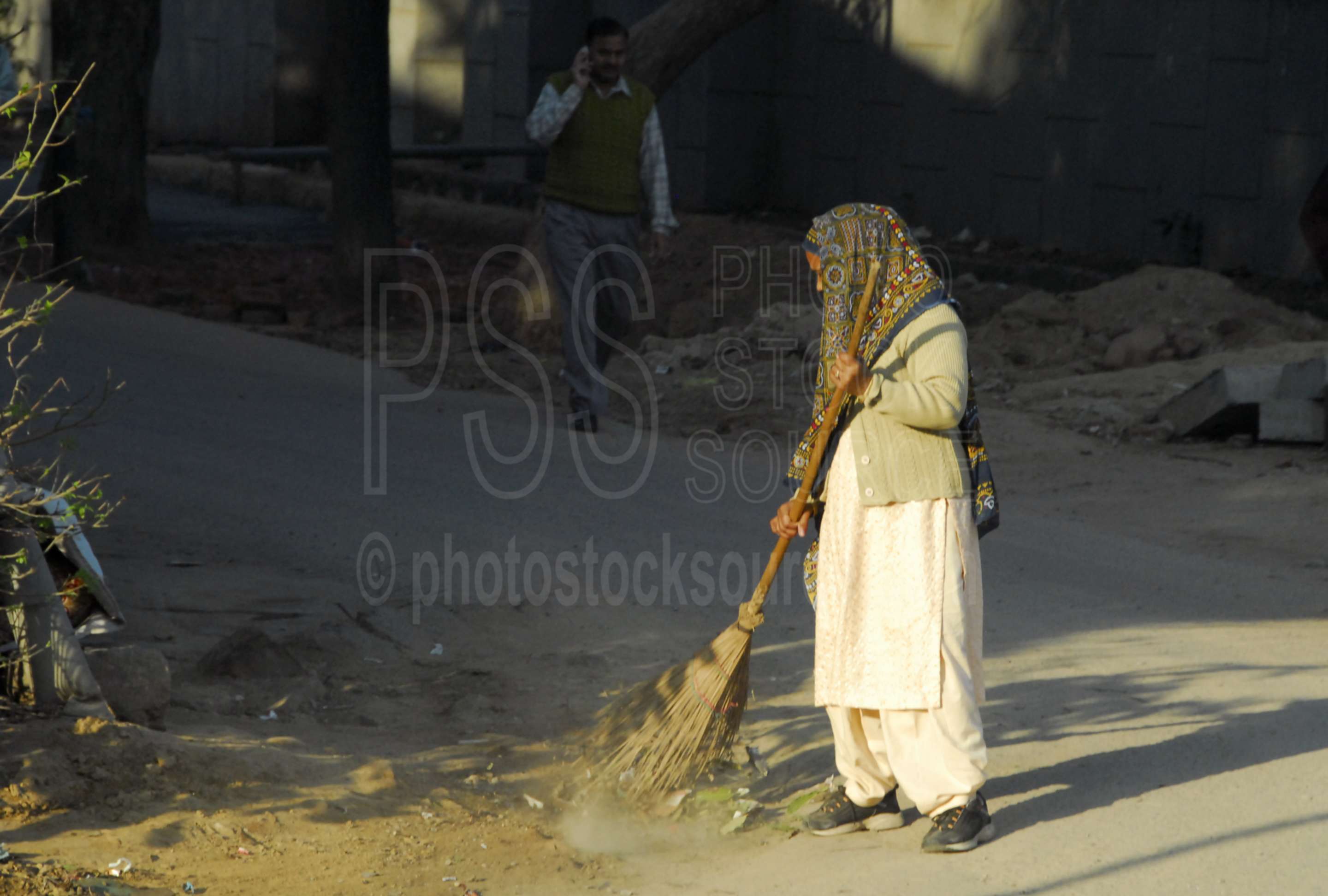 Photo of Woman Sweeping Street by Photo Stock Source people, New Delhi